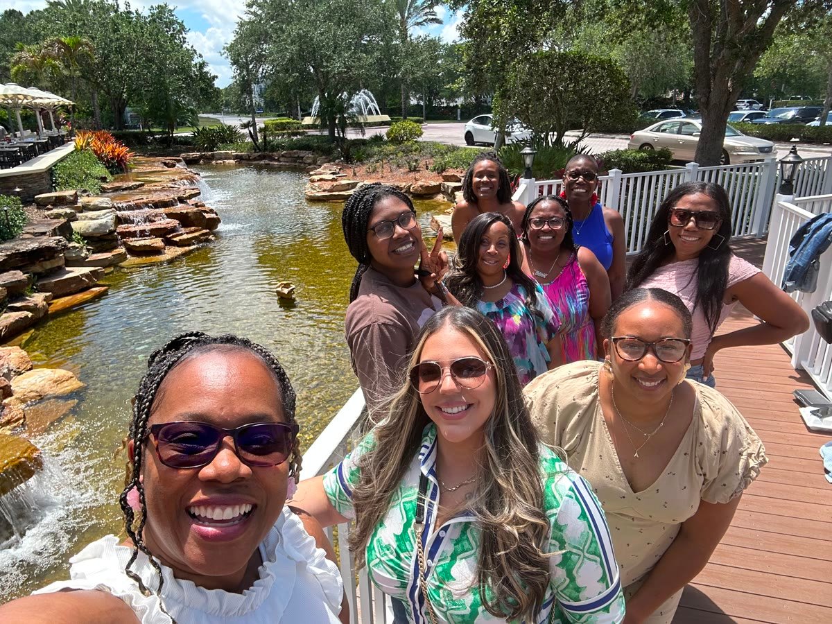 The Women’s Tribe together outdoors by a pond